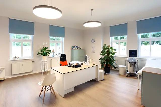 Behandlungszimmer der Hausarztpraxis Dr. Evers mit Schreibtisch, Stauraumschrank und funktionalen Einbauten